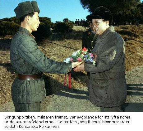 kim_jong_il_får_blommor_av_soldat_färg_text.jpg
